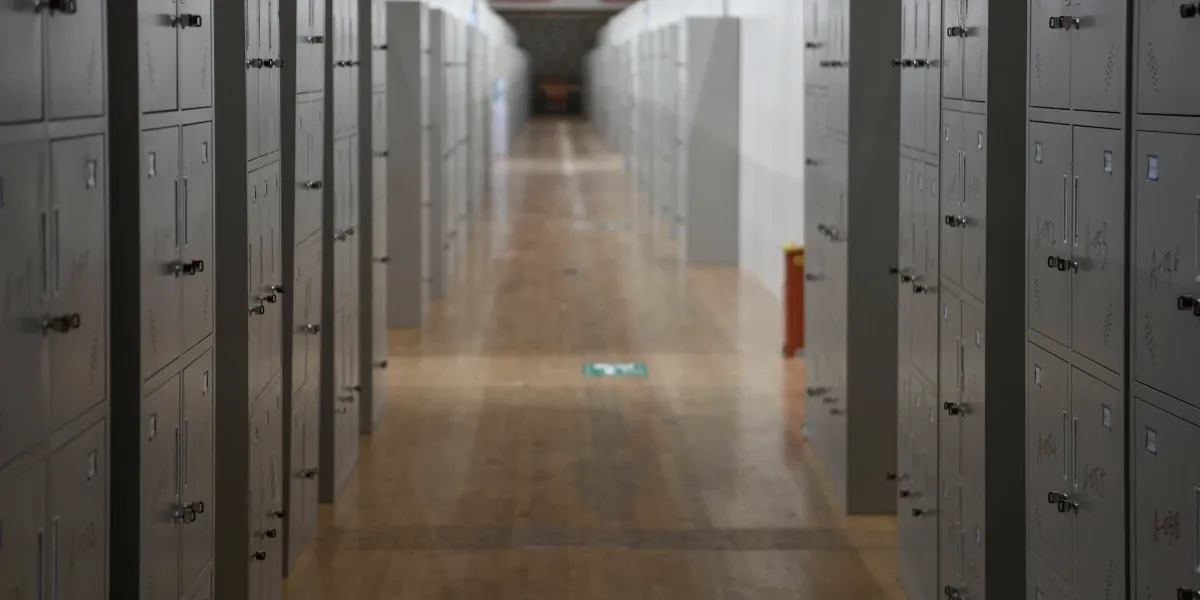 Long corridor of closed grey storage lockers over a timber floor